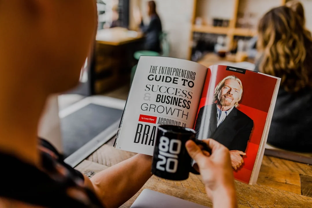Two businessmen analyze stock market data using a smartphone and laptop in a modern office setting.